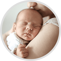 Woman cradling a newborn baby in her arms, providing a safe and secure environment for them to sleep
